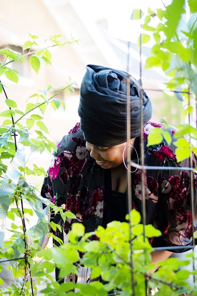 Aja Yasir checking on her plants in her garden in Gary, Indiana. Photo by Aja's son, Heru.