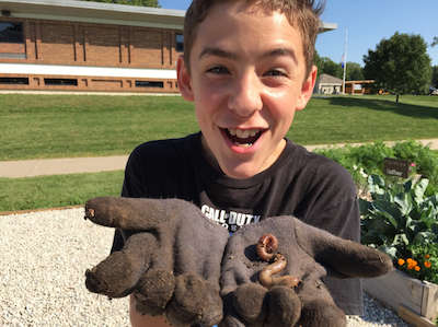 up close of excited boy holding a worm