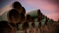 Image: pipes stacked in a field. Topic: Break Up With Your DAPL-Supporting Bank.