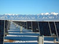 Image: solar panels in a field with snow-capped mountains beyond. Title: Solar Power Leases: Avoid the Big Initial Costs