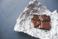 Image: chocolate in tinfoil wrapper. Title: Spotlight on Hershey and Child Labor, Two Years Later