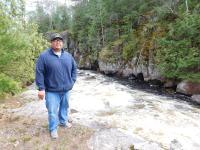 Guy Anahkwet Reiter stands near the Menominee River, which is sacred to the Menominee Tribe.