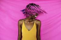 girl shaking her pink hair in front of a pink background