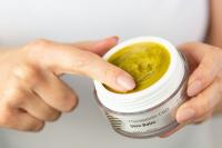 white person rubs their index finger in a yellow balm labeled "Therapeutic CBD skin balm", hemp-cbd is on the rise