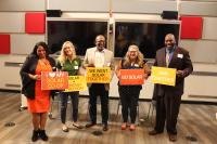 Image: people stand holding signs that say "I love my solar co-op, "Solar = Energy Freedom," "We Want Solar Together!," "Go Solar," and "Join Together." Title: Getting to 100% Clean Energy, Equitably