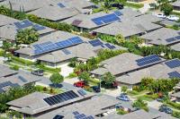 aerial view of homes with solar panels, financing solar panels is a big barrier