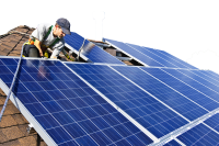 solar technician installing solar panels on a roof