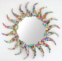 A round mirror decorated with papier-mâché in the shape of a sun. Mirrors Decorated.