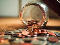 Image: coins falling out of a jar. Topic: better banking for people and the planet