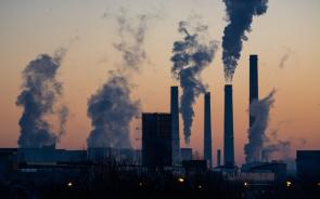 energy plants emitting clouds of pollution against sunset 