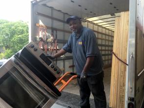 A Community Forklift staff member unloads a donated kitchen range