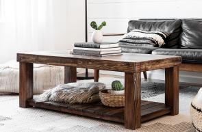 Solid real wood coffee table with bottom shelf in a deep, rich brown stain in front of a leather and wood couch surrounded by southwest decor items