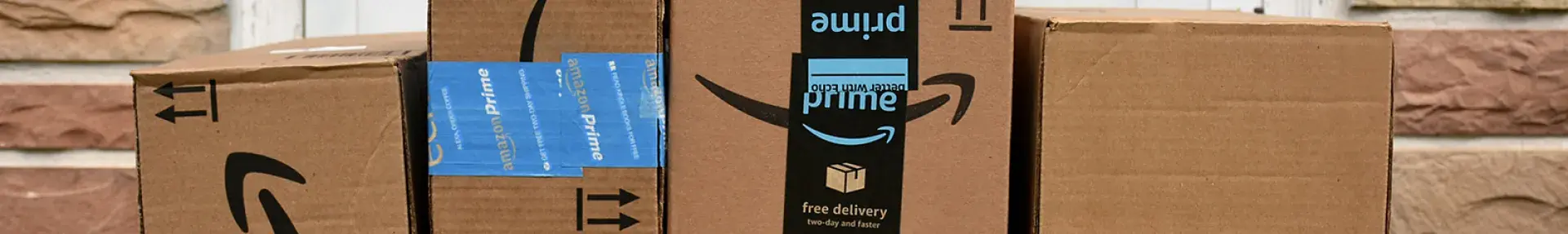 Image: stack of Amazon boxes in front of door. Topic: Why Is Amazon Bad?