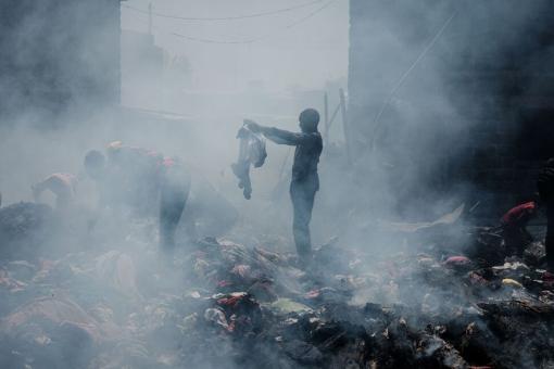 A man scavenges clothes from debris burnt down by the fire in the early morning at Gikomba market, East Africa's largest second hand clothing market, in Nairobi, Kenya, on Nov. 8, 2021.(YASUYOSHI CHIBA/AFP VIA GETTY IMAGES)
