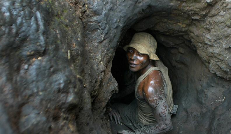 Man enters hand-dug tunnel.
