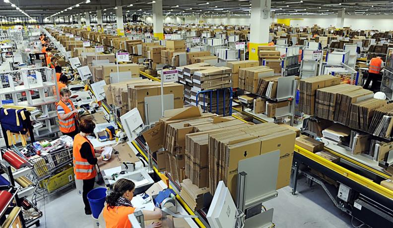 Image: Amazon workers packaging items in a warehouse. Topic: Why We Should Quit Amazon