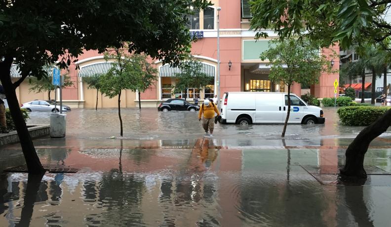 man walks through flood in Miami
