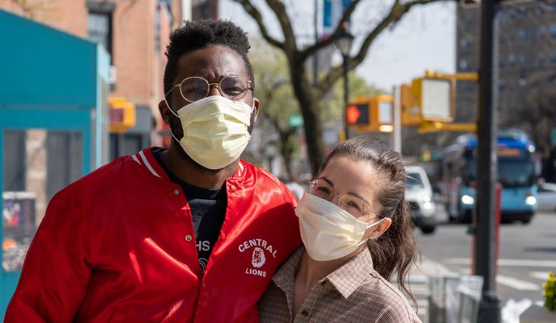 couple poses on the street with masks