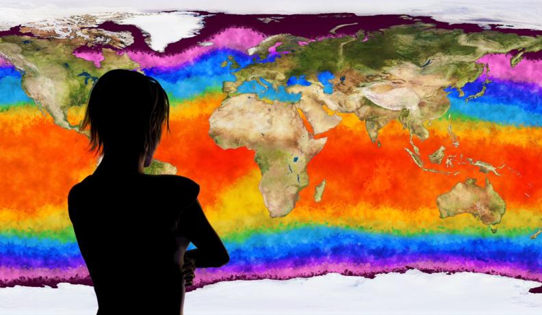 silhouette of a person looking at a map where the ocean is a rainbow