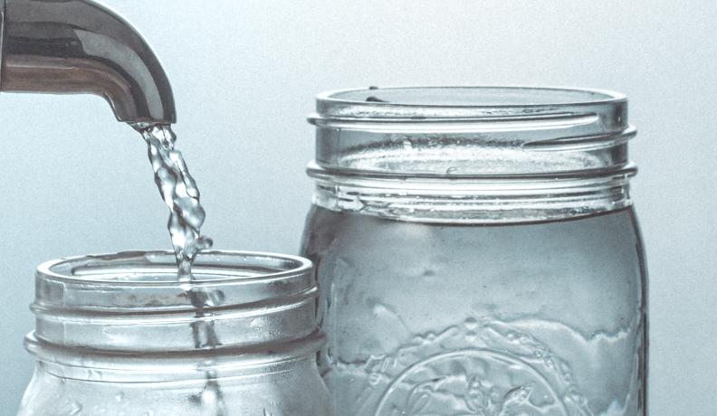 water coming out of tap into two mason jars