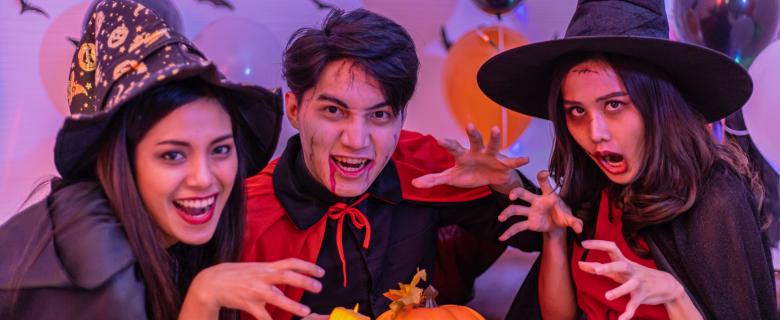 Three young Asian people dressed up for Halloween at a party. Sustainable Halloween Costumes.