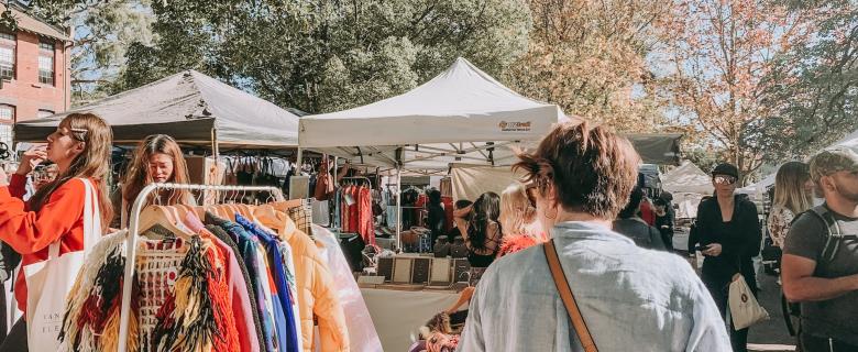 People shopping at a local, outdoor market. Ethical shopping resolutions.