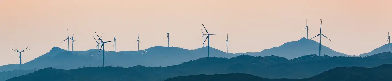 Image: wind turbines on a ridgeline. Topic: socially responsible investing can include energy from wind