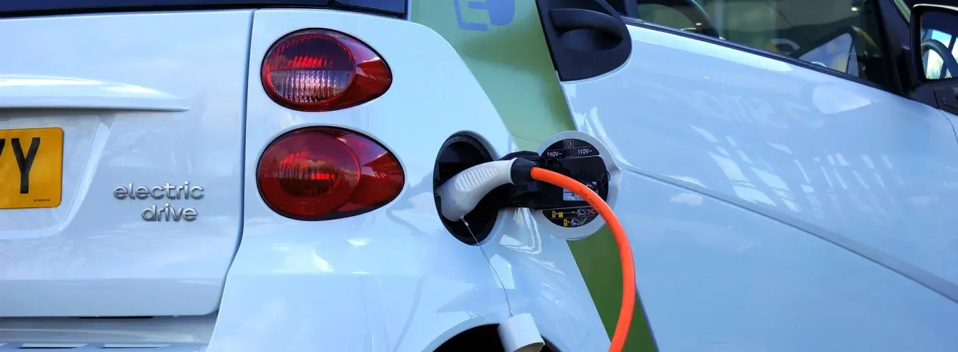 Image: hybrid vehicle plugged in. Topic: The Money-Saving Perks of a Hybrid Car