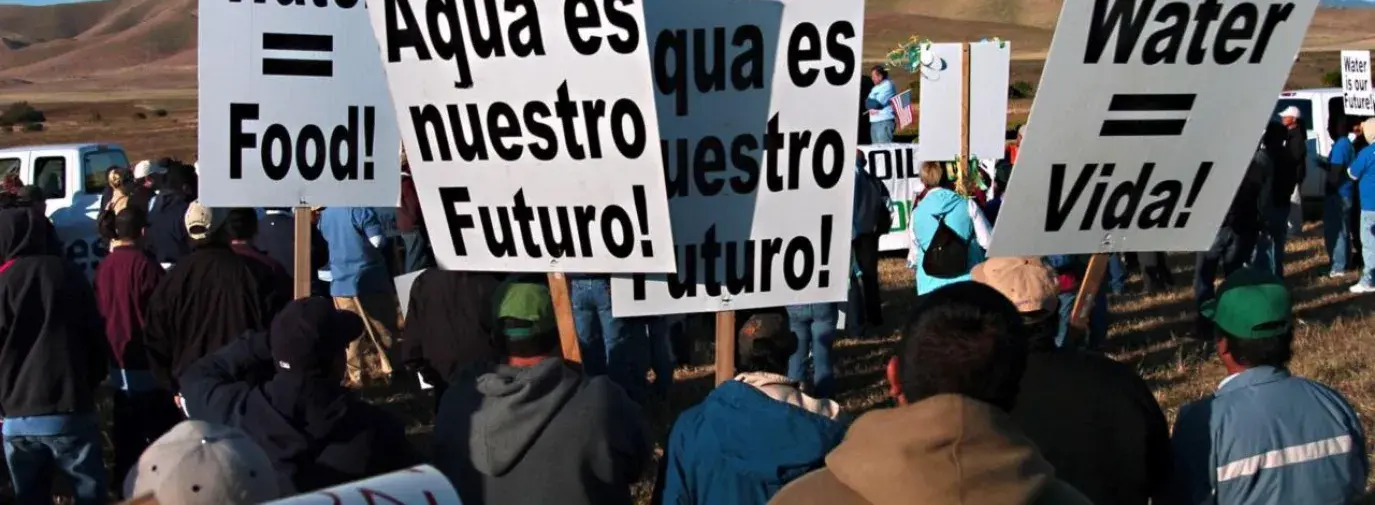 Image: marchers carrying signs, "Agua es nuestro futuro." Title: The Power of Latino Voices in Environmental Justice
