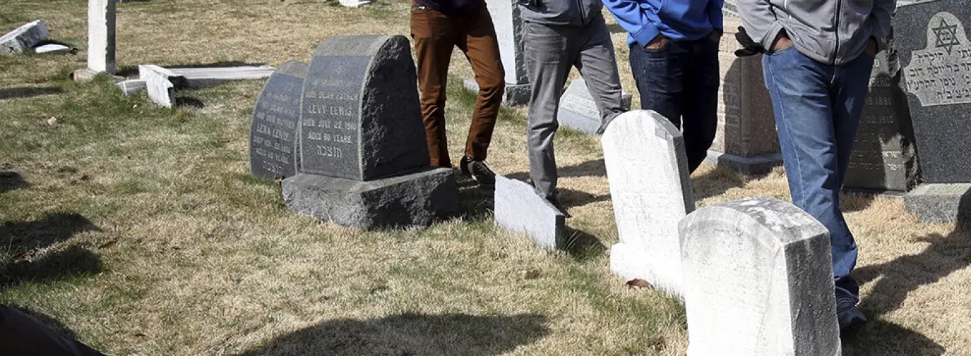 Ahmadiyya Muslim volunteers walk through Mount Carmel Cemetery in Philadelphia, where vandals desecrated Jewish headstones in February