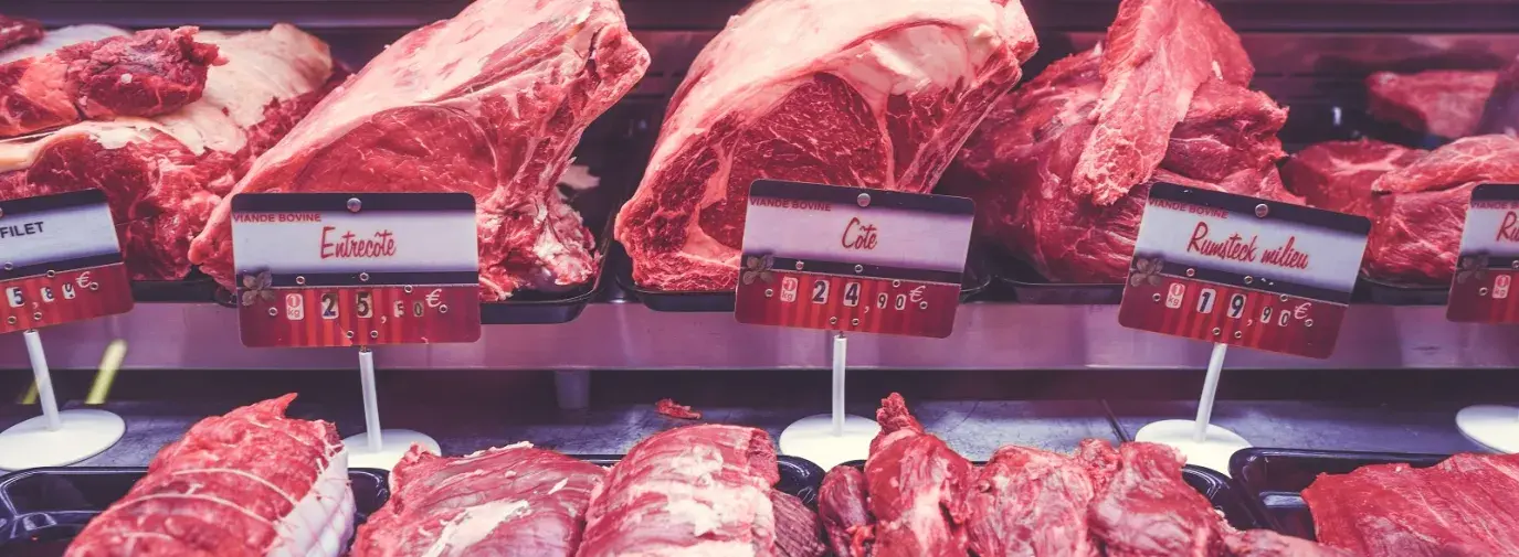Image: rows of red meat in grocery case. Topic: Go Vegetarian: Eat Less Meat to Cool the Planet