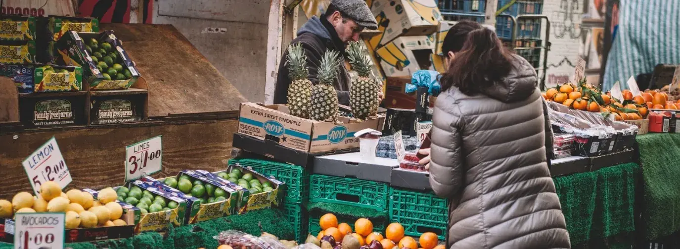 Image: street market with fruit and vegetables. Article: Buying Local and Going Green