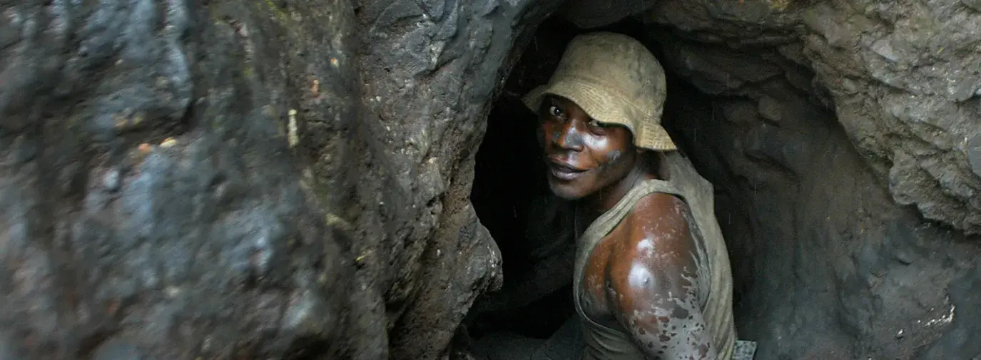 Man enters hand-dug tunnel.