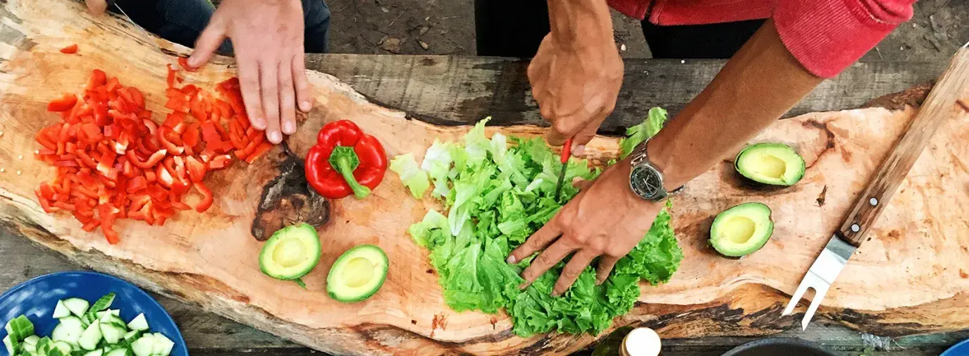 Image: hands chopping colorful vegetables. Topic: Green Living: 10 Habits of Highly Sustainable People