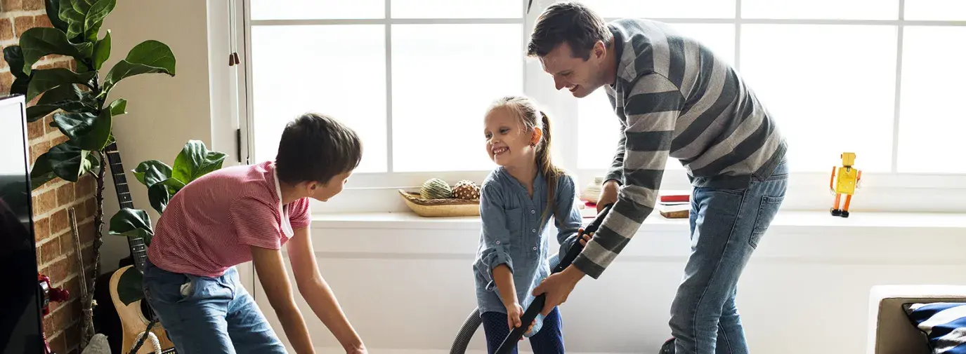 Image: dad and kids vacuuming, creating a germ-free home