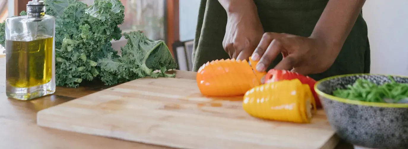 Image: woman chopping peppers. Topic: 5 Foods to Boost Your Immune System