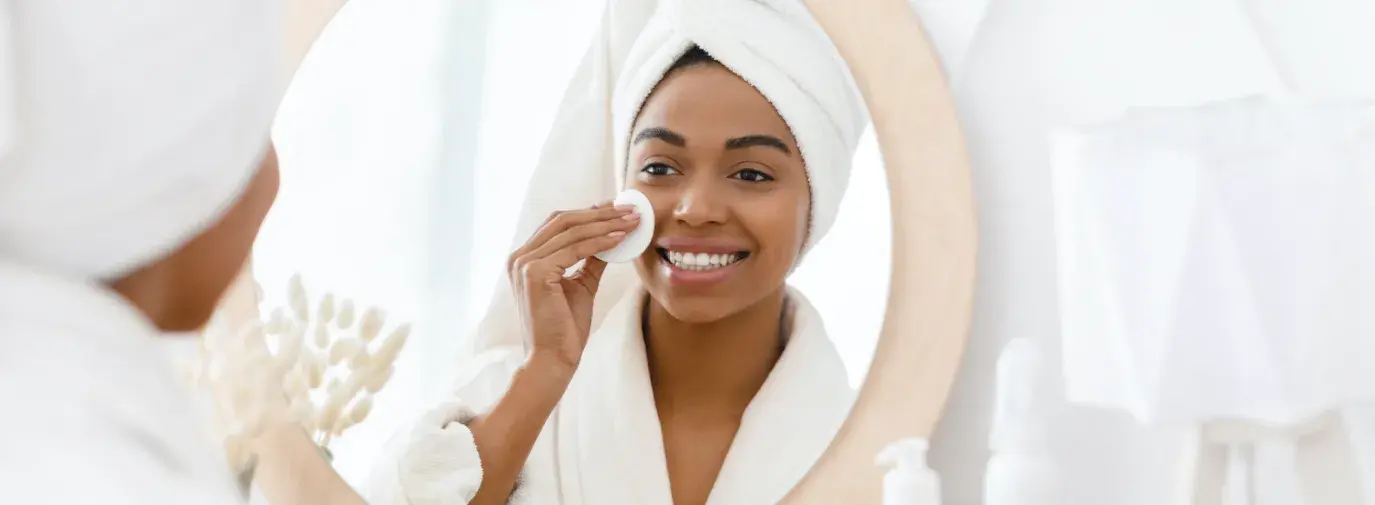 Black woman applying face products.