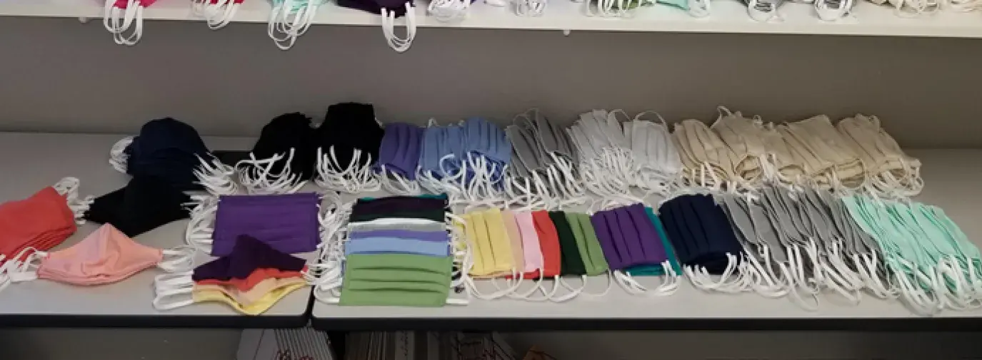 multicolored face masks on a white shelf