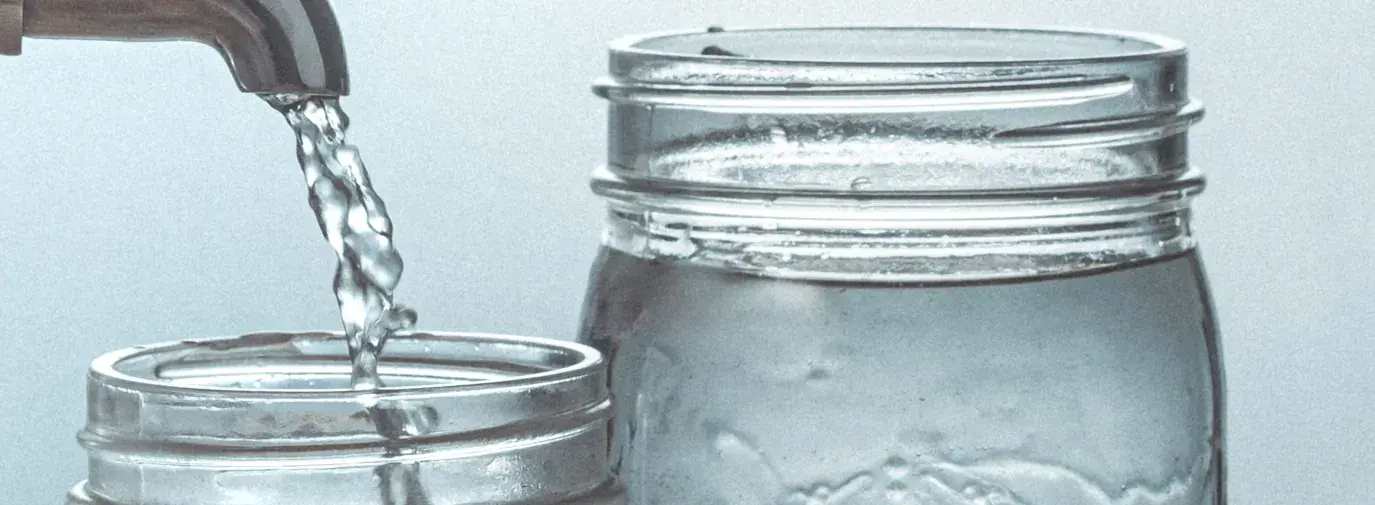 water coming out of tap into two mason jars