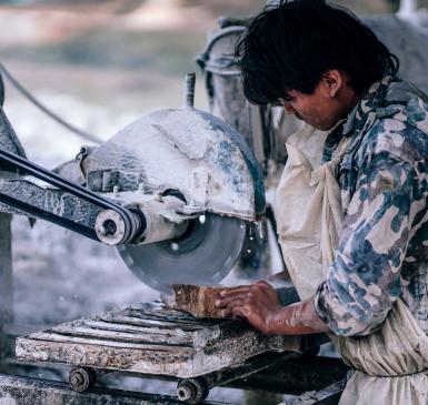 Image: laborer working with machinery. Topic: Fair labor.