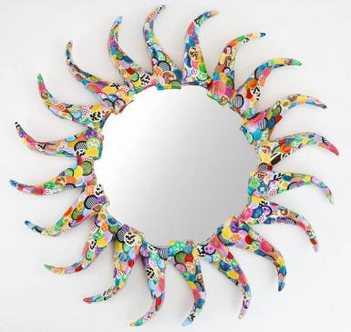 A round mirror decorated with papier-mâché in the shape of a sun. Mirrors Decorated.