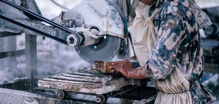 Image: laborer working with machinery. Topic: Fair labor.