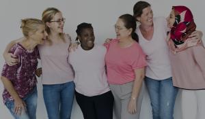 Image: diverse group of women embracing and smiling. Title: Why Investing in  Women Pays Off