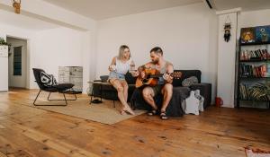 Image: man and woman in living room with wood flooring. Topic: Eco-friendly flooring