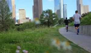 Two people running on a sidewalk at Buffalo Baou Park in Houston, Texas. Photo from City Park Alliance