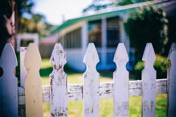 Image: picket fence in front of a home. Topic: Mortgages from Responsible Banks and CDFIs